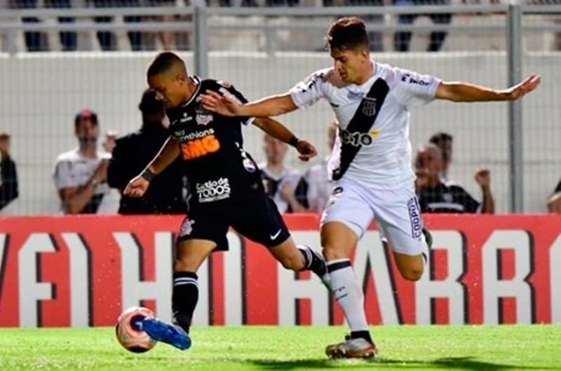 jogadores de futebol disputam bola