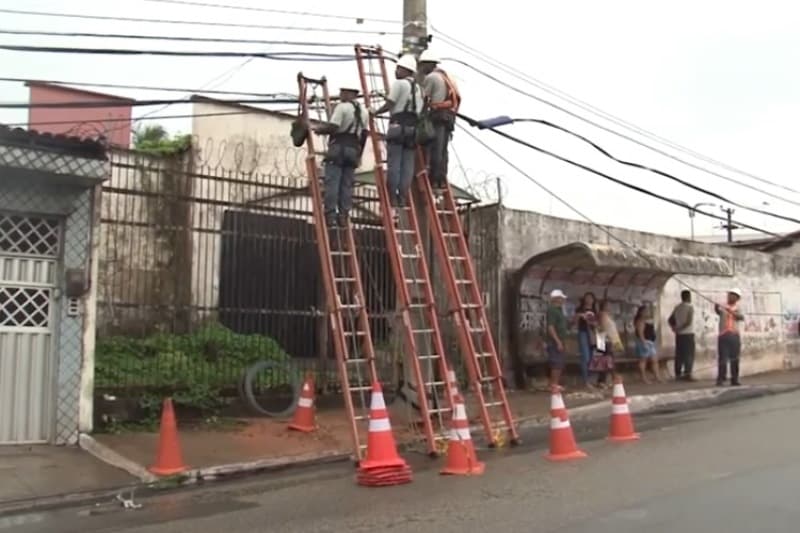 eletricistas trabalham em poste